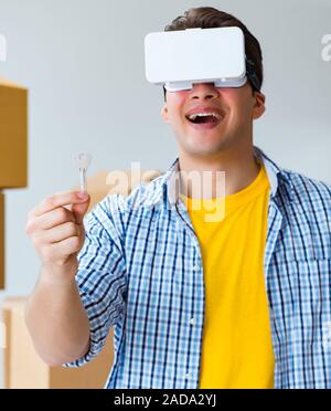 Young man wearing VR glasses moving in new apartment Stock Photo