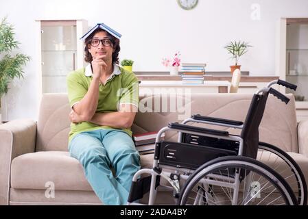 Young male student in wheelchair at home Stock Photo