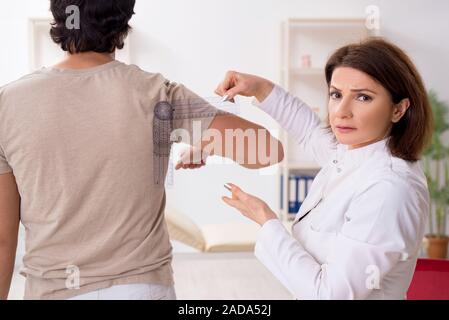 Female doctor checking patient's joint flexibility with goniometer Stock Photo