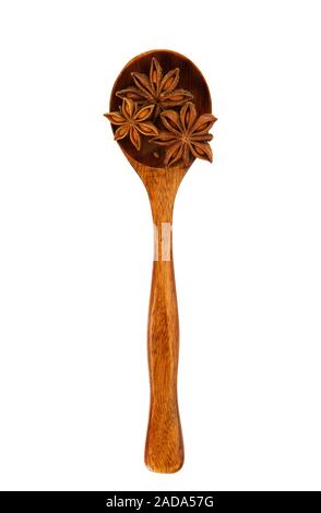 Anise in a spoon on an isolate. Seasoning on isolate. View from above. Star anise seeds on isolate. Dry spices. Stock Photo