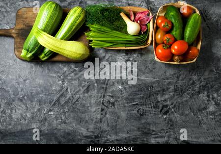 Vegetables on the background. Fresh vegetables (cucumbers, tomatoes, onions, garlic, dill, green beans) on a gray background. To Stock Photo