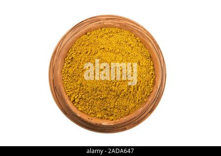 Curry in a clay cup isolated on a white background. Spice on isolate. View from above. Dry seasoning. Stock Photo