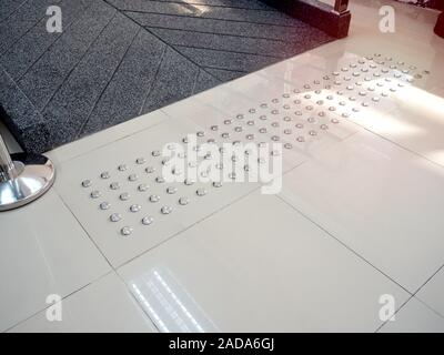 Metallic dot tactile floor, blind path for blind people near the slope path. Stock Photo
