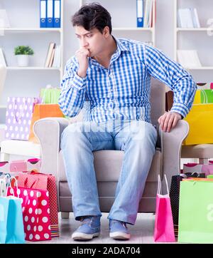 Young man after excessive shopping at home Stock Photo