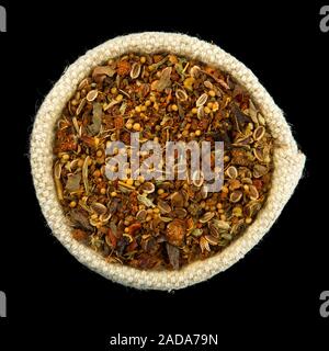 Mix of spices in a bag isolated on black background. View from above. Seasoning on isolate. Dry spices. Stock Photo