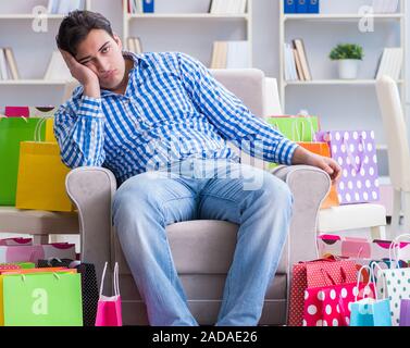 Young man after excessive shopping at home Stock Photo