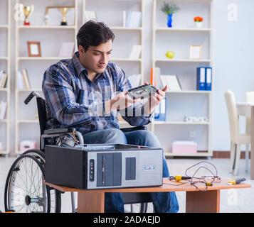 Computer repairman on wheelchair working Stock Photo