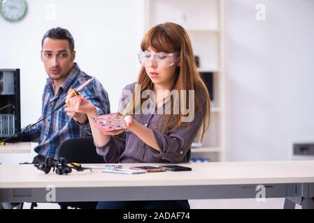 Two technicians working at computer warranty center Stock Photo