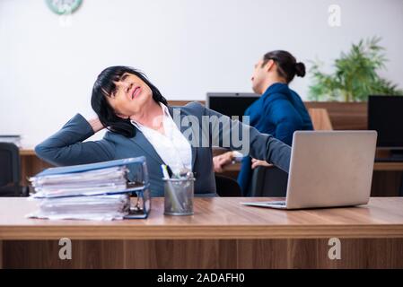 Two employees doing sport exercises in the office Stock Photo