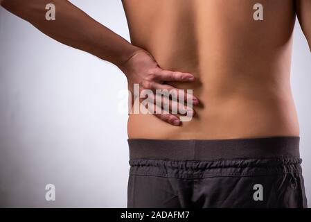 Man suffering from backbain on gray Stock Photo