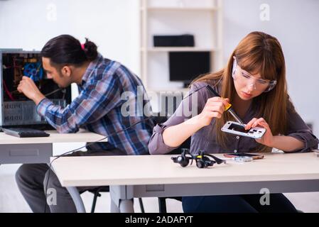 Two technicians working at computer warranty center Stock Photo