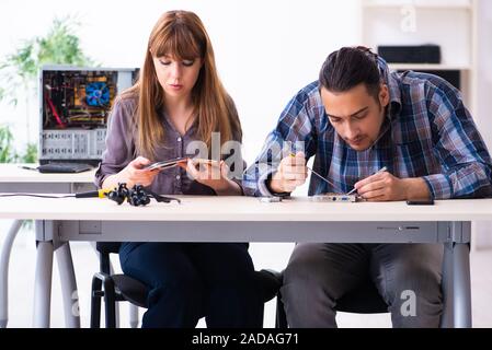 Two technicians working at computer warranty center Stock Photo
