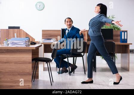 Two employees doing sport exercises in the office Stock Photo