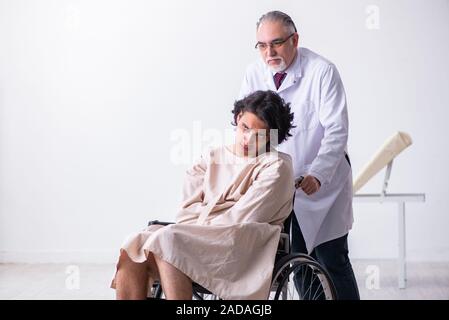 Old male doctor psychiatrist and patient in wheel-chair Stock Photo