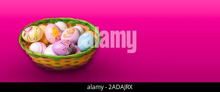 Wicker basket with Easter eggs hand painted on color tabletop background Stock Photo