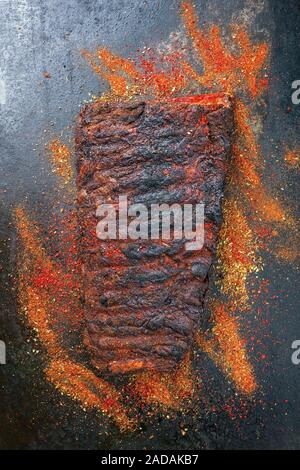 Barbecue spare ribs St Louis cut hot rub as closeup on a black board Stock Photo