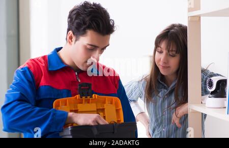 Client getting securty camera installed at home by contractor Stock Photo
