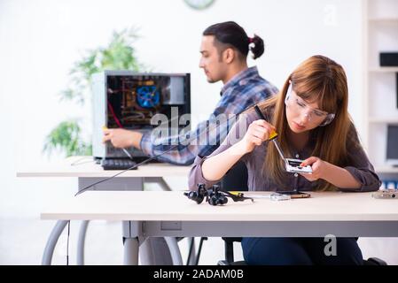 Two technicians working at computer warranty center Stock Photo