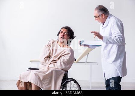 Old male doctor psychiatrist and patient in wheel-chair Stock Photo