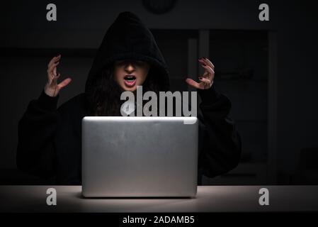 Female hacker hacking security firewall late in office Stock Photo