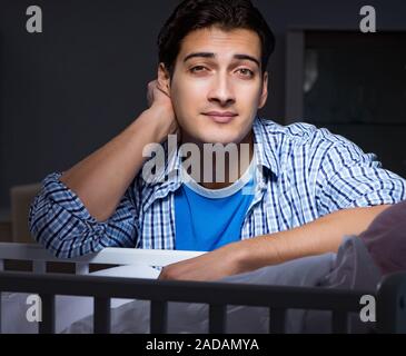 Happy dad looking after newborn baby at night Stock Photo