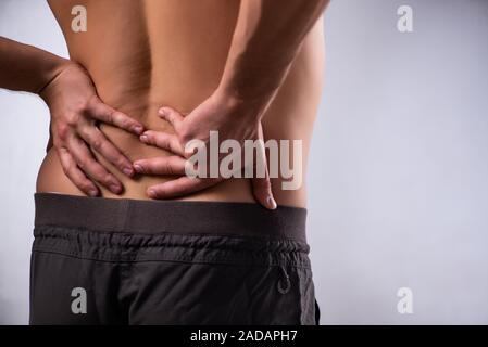 Man suffering from backbain on gray Stock Photo