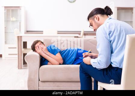 Internet addicted boy visiting male doctor Stock Photo