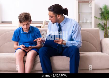 Internet addicted boy visiting male doctor Stock Photo