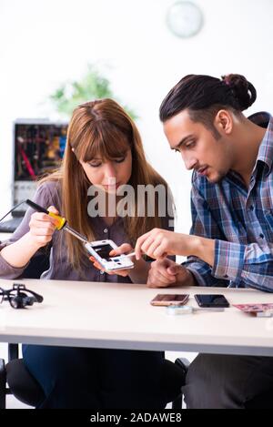 Two technicians working at computer warranty center Stock Photo