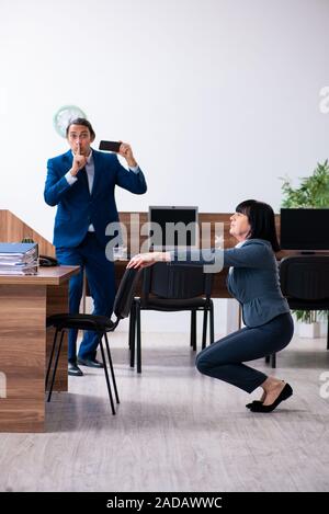 Two employees doing sport exercises in the office Stock Photo