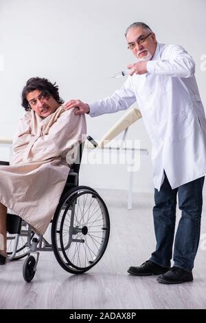 Old male doctor psychiatrist and patient in wheel-chair Stock Photo