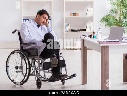 Doctor resting on wheelchair in hospital after night shift Stock Photo