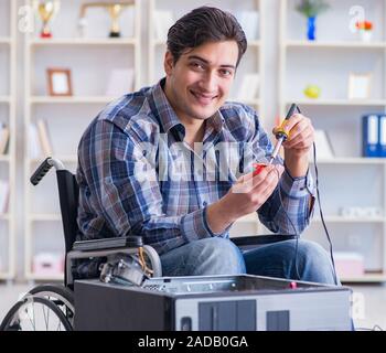Computer repairman on wheelchair working Stock Photo