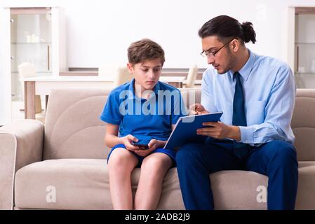 Internet addicted boy visiting male doctor Stock Photo