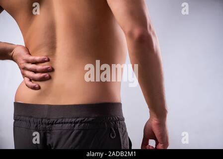 Man suffering from backbain on gray Stock Photo