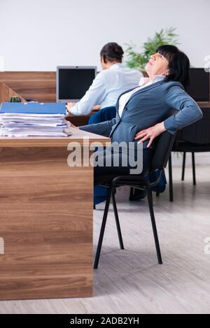 Two employees doing sport exercises in the office Stock Photo