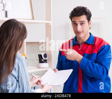 The client getting securty camera installed at home by contracto Stock Photo