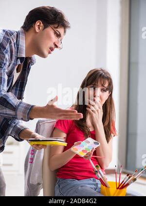Artist coaching student in painting class in studio Stock Photo - Alamy