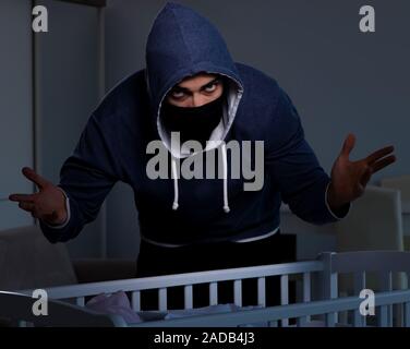 The criminal stealing baby in human child traficking concept Stock Photo