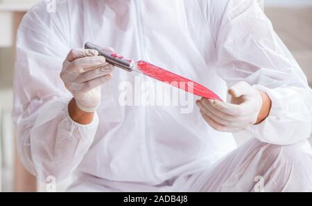 Forensic expert at crime scene doing investigation Stock Photo