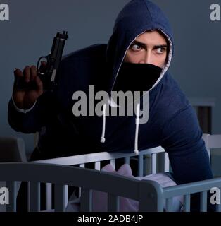 Criminal stealing baby in human child traficking concept Stock Photo