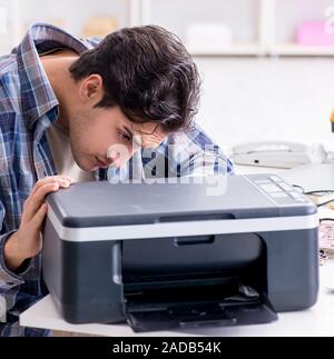Hardware repairman repairing broken printer fax machine Stock Photo