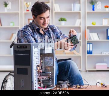 Computer repairman on wheelchair working Stock Photo