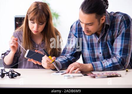 Two technicians working at computer warranty center Stock Photo