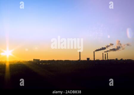Sunrise silhouette of city landscape with smoking factory, ecology pollution concept Stock Photo