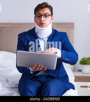 Businessman with neck injury working from home Stock Photo