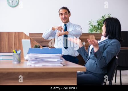 Two employees doing sport exercises in the office Stock Photo