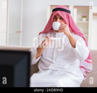 Arab Businessman watching tv at home Stock Photo