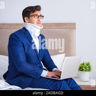 Businessman with neck injury working from home Stock Photo