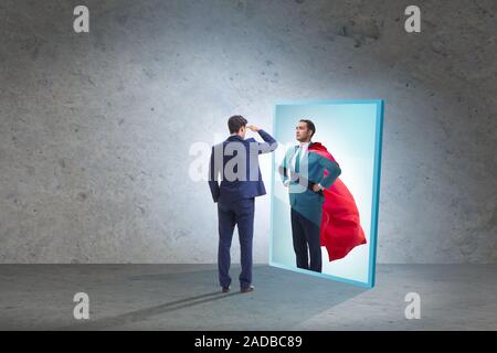 Businessman seeing himself in mirror as superhero Stock Photo
